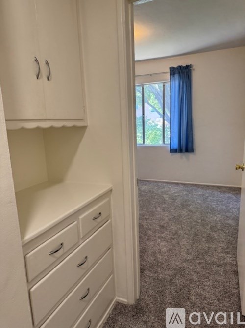 A room with a window and a carpeted floor.