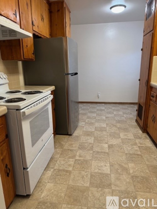 A kitchen with a white stove and a white refrigerator.
