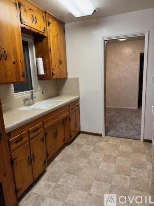 A kitchen with wooden cabinets and a checkered floor.