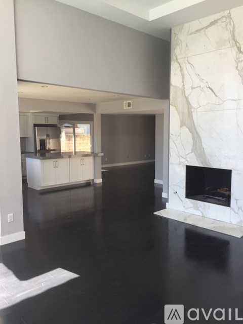 A modern kitchen with a marble fireplace.