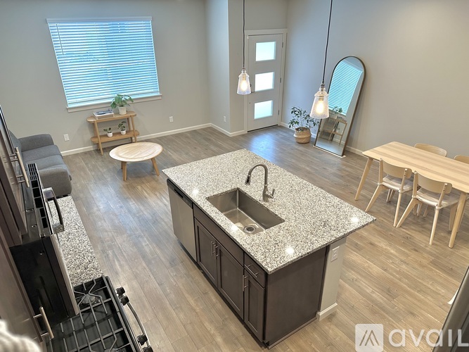 A kitchen with a granite countertop and wooden flooring.