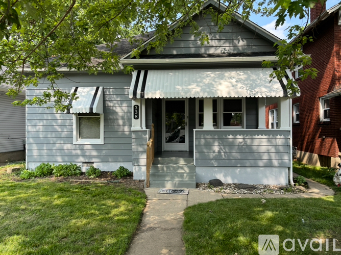 A house with a grey exterior and a white awning.