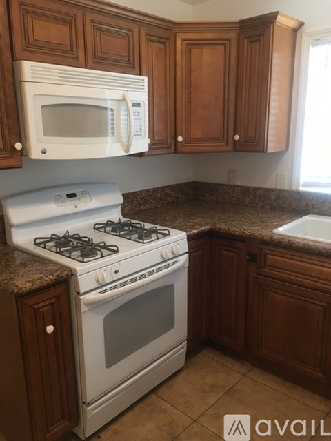 A kitchen with a white stove and brown cabinets.