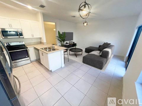A kitchen with white cabinets and a black stove top oven.