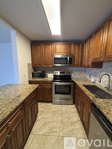 A kitchen with wooden cabinets and granite countertops.