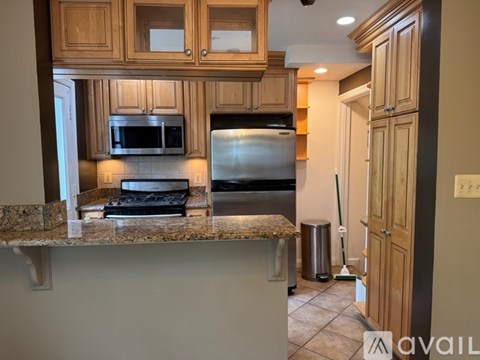 A kitchen with wooden cabinets and a granite countertop.