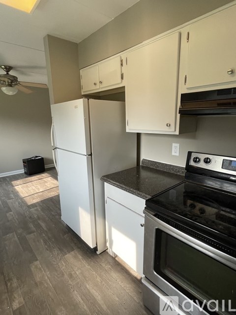 A kitchen with a white refrigerator and black stove.