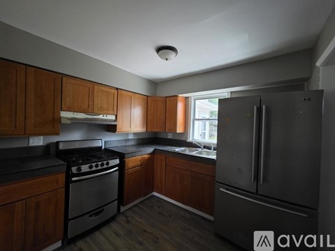 A kitchen with wooden cabinets and a stainless steel refrigerator.