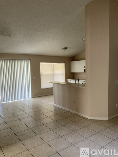 A spacious kitchen area with white cabinets and a countertop.