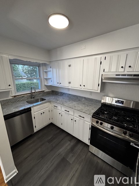 A kitchen with white cabinets and a black stove top oven.