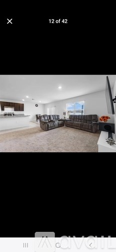 A living room with a brown couch and a television.