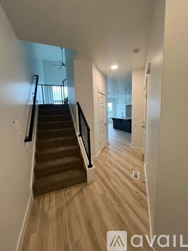 A hallway with wooden floors and a staircase leading to the second floor.