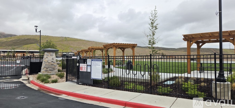 A gated community entrance with a sign and a mountain in the background.