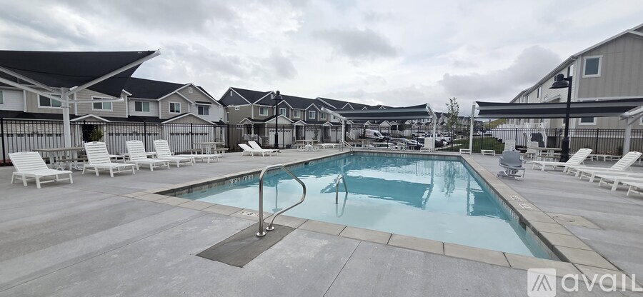 A pool surrounded by lounge chairs in a residential area.