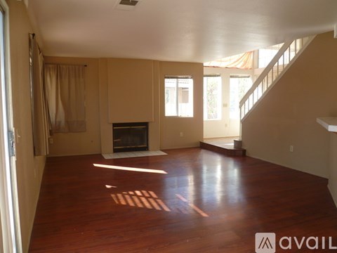 A spacious living room with a fireplace and wooden floors.