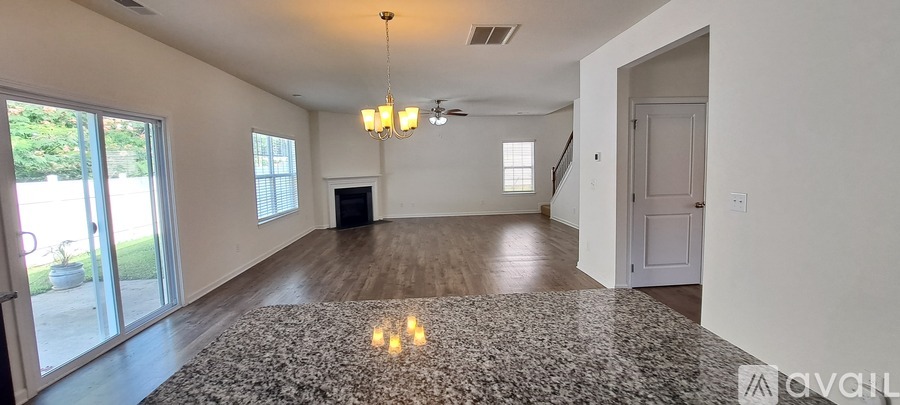 A spacious living room with a fireplace and a chandelier.