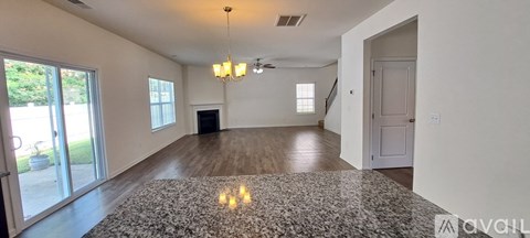 A spacious living room with a fireplace and a chandelier.