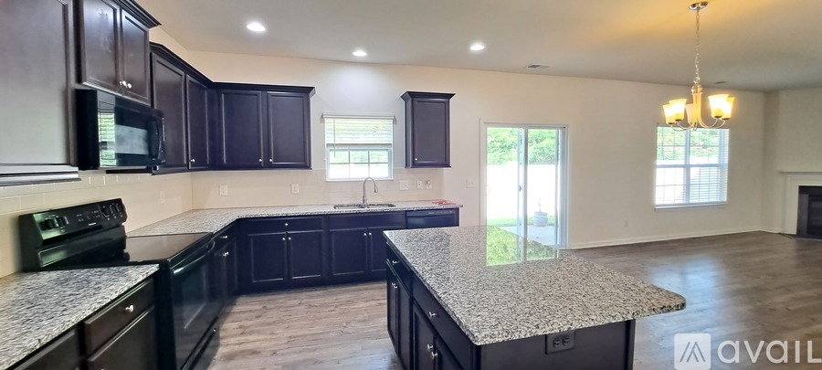 A kitchen with dark wood cabinets and granite countertops.