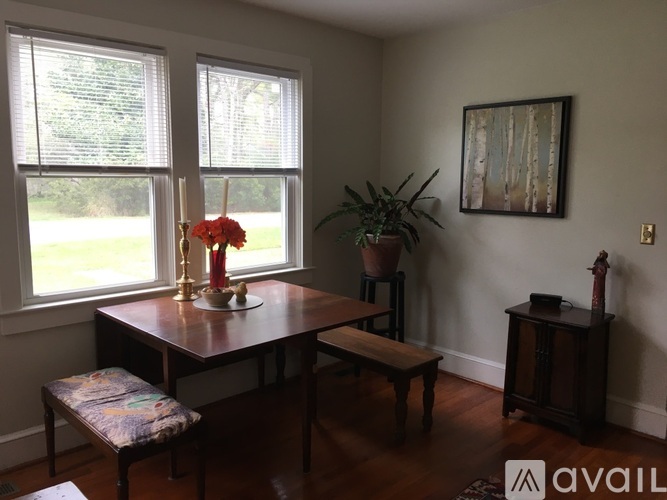 A dining room with a wooden table and chairs.