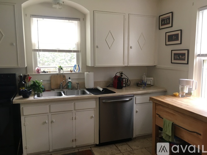 A kitchen with white cabinets and a window above the sink.