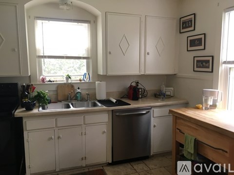 A kitchen with white cabinets and a window above the sink.