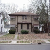 A house with a brown roof and a white fence.