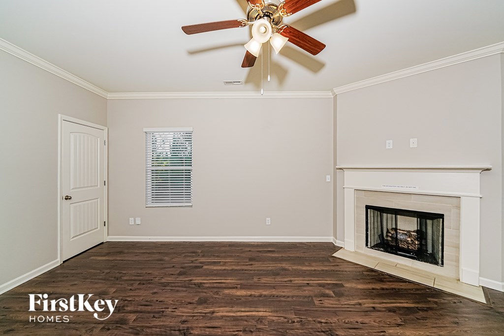 A room with a fireplace and a ceiling fan.
