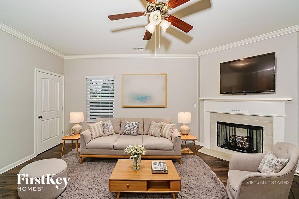A living room with a fireplace and a television on the wall.