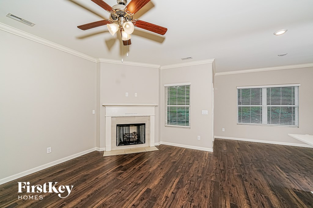 A room with a fireplace and a ceiling fan.