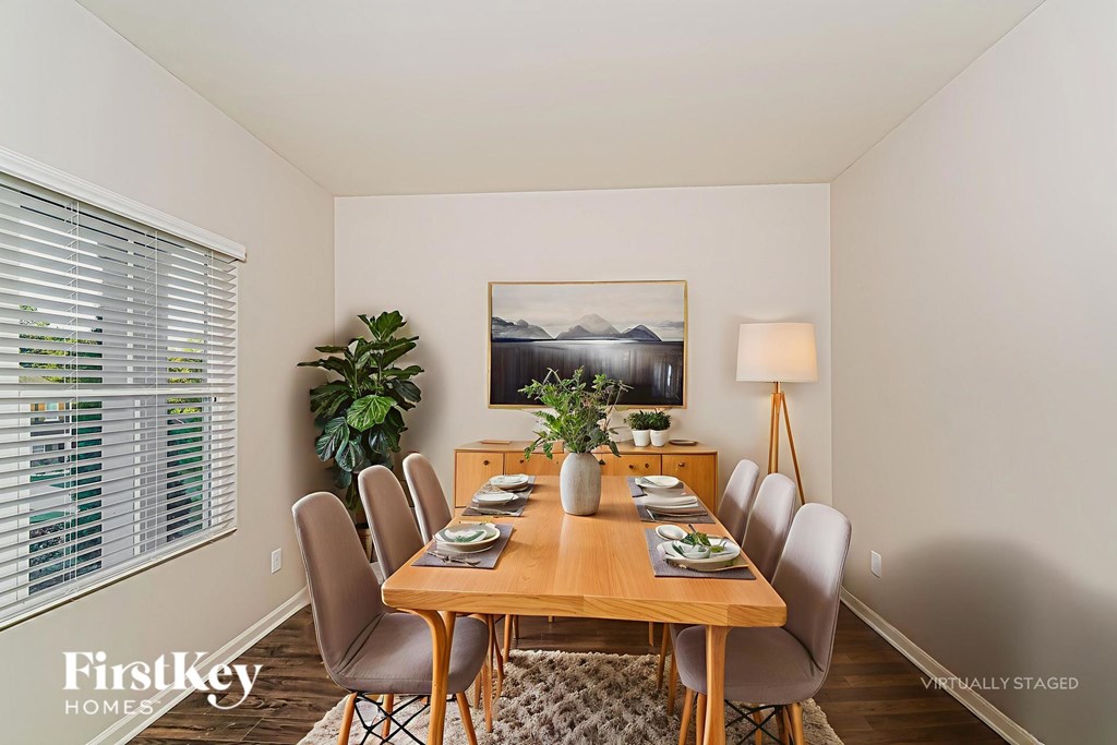 A dining room with a wooden table set for six.