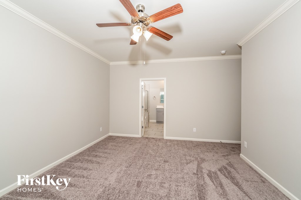 A room with a ceiling fan and a carpeted floor.