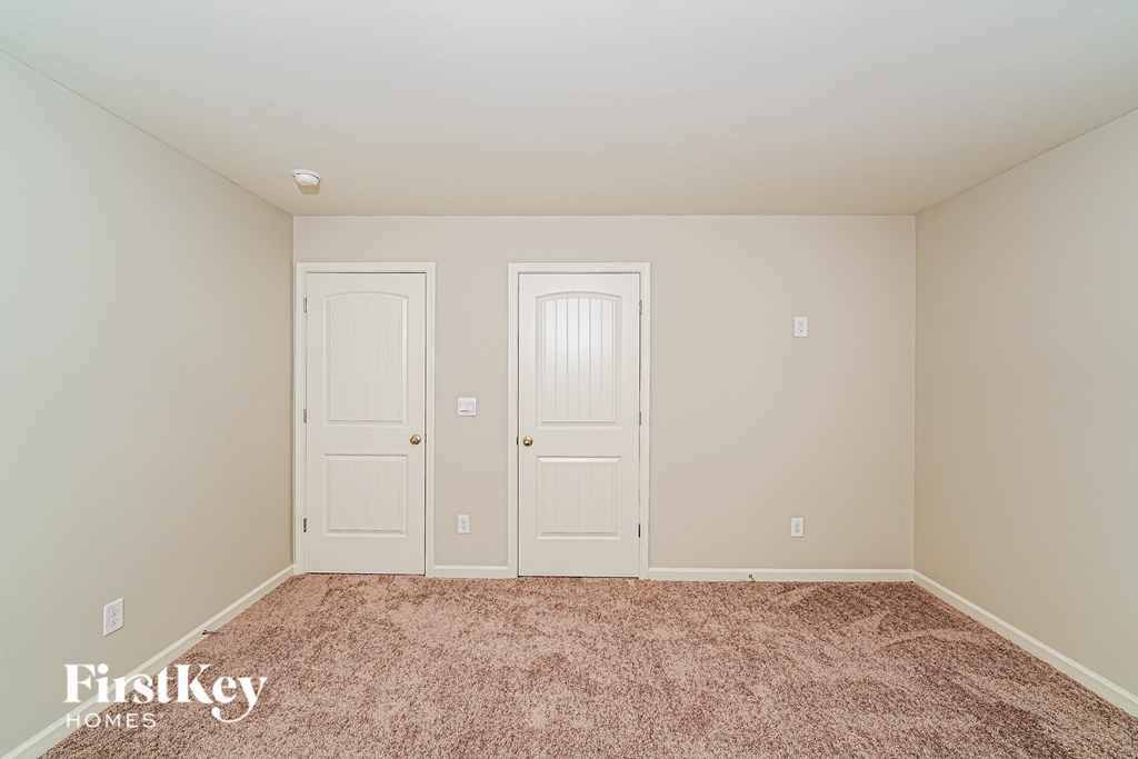 A room with two doors and a carpeted floor.