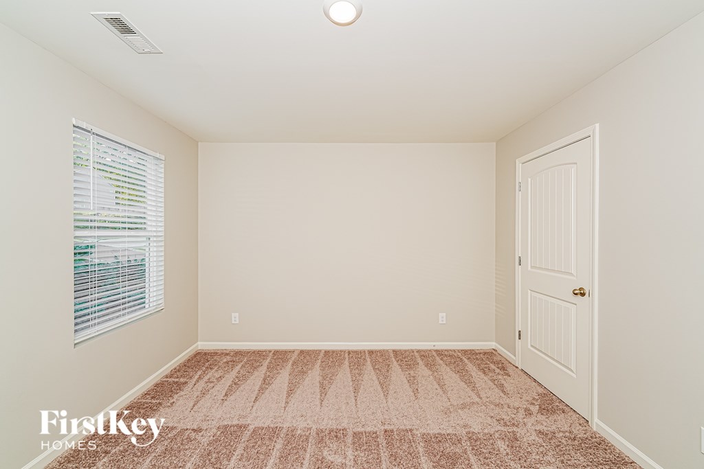 A room with a carpeted floor and a door.