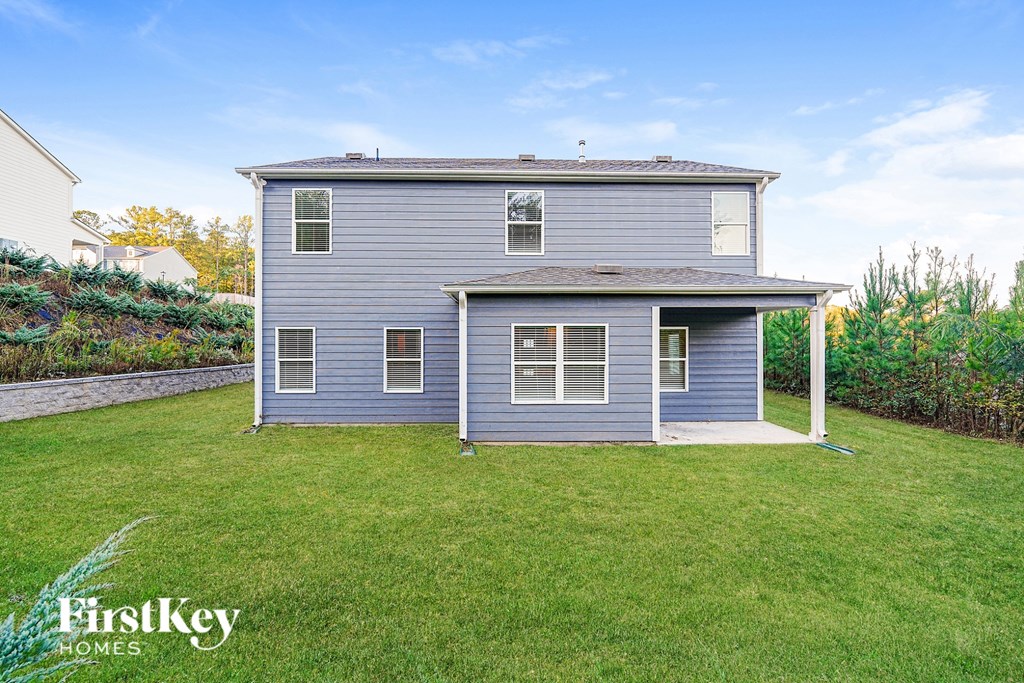 A grey house with a green lawn in front of it.