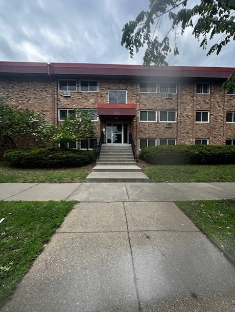 A building with a red roof and a set of stairs leading to the entrance.