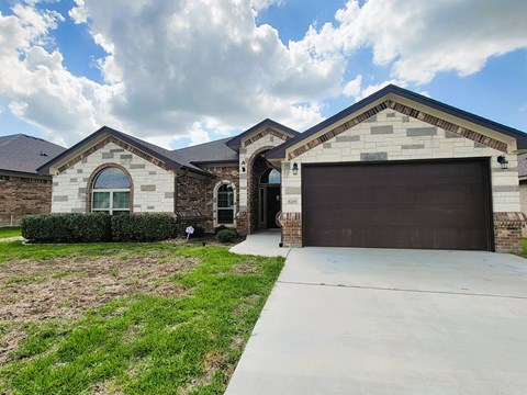 A house with a garage door and a driveway.