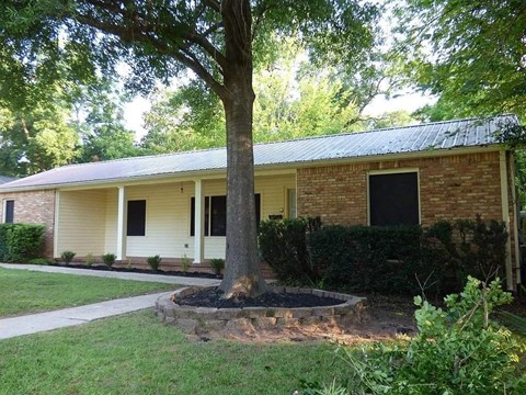 A house with a tree in front of it.