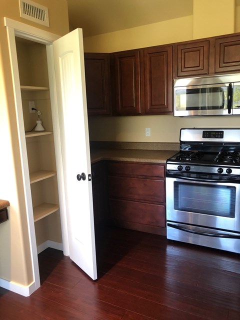 A kitchen with a stove and an open door.