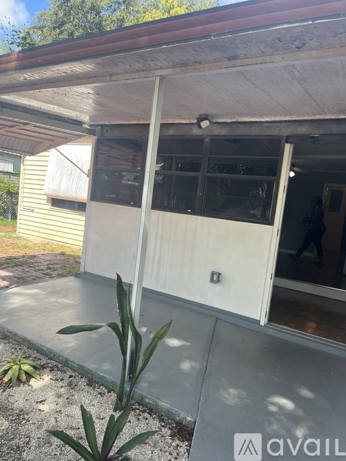 A house with a white door and a small plant in front.