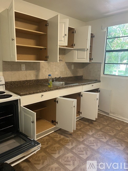 A kitchen with white cabinets and a patterned floor.