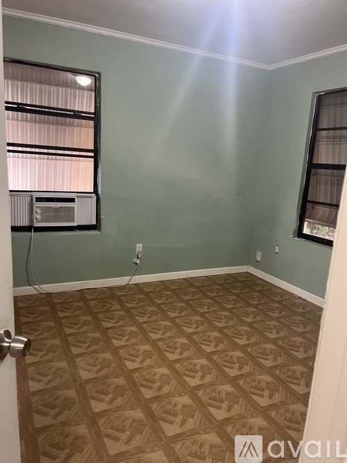 A room with a tan patterned floor and a window with blinds.
