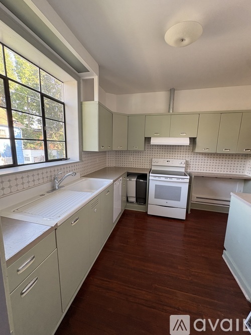 A kitchen with white cabinets and a white sink.