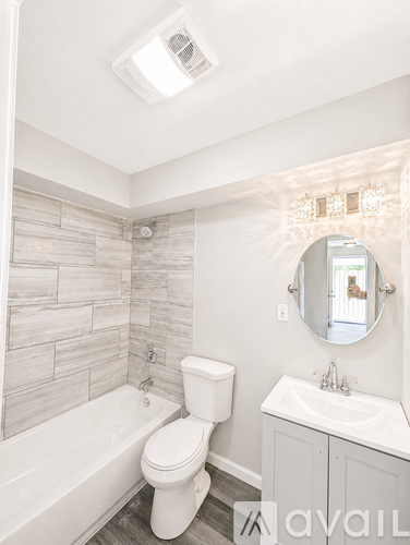 A white toilet sits next to a bathtub in a bathroom.