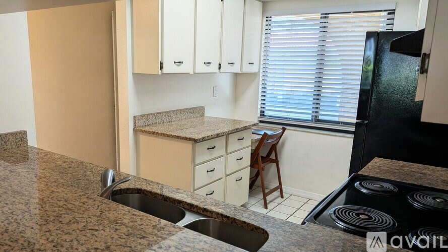 A kitchen with granite countertops and white cabinets.