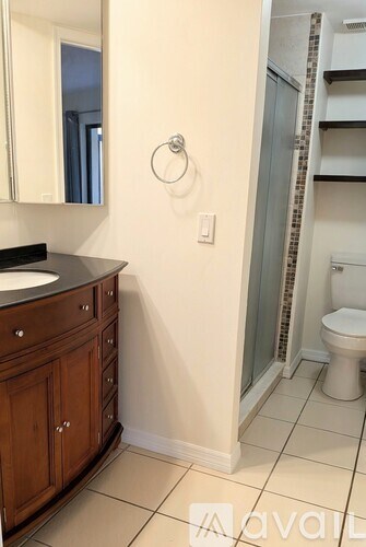 A bathroom with a toilet, sink, and mirror.