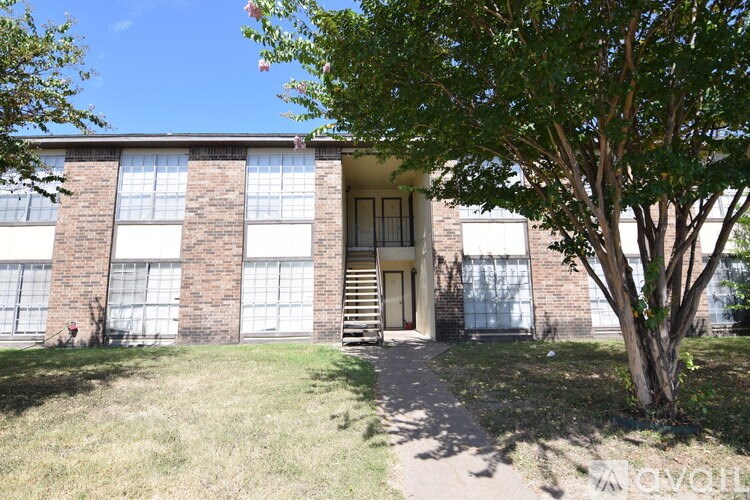 A tree is in front of a building with a flag on it.