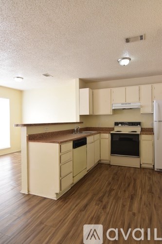 A kitchen with wooden floors and white cabinets.