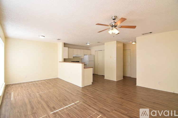 A spacious room with a ceiling fan and wooden flooring.