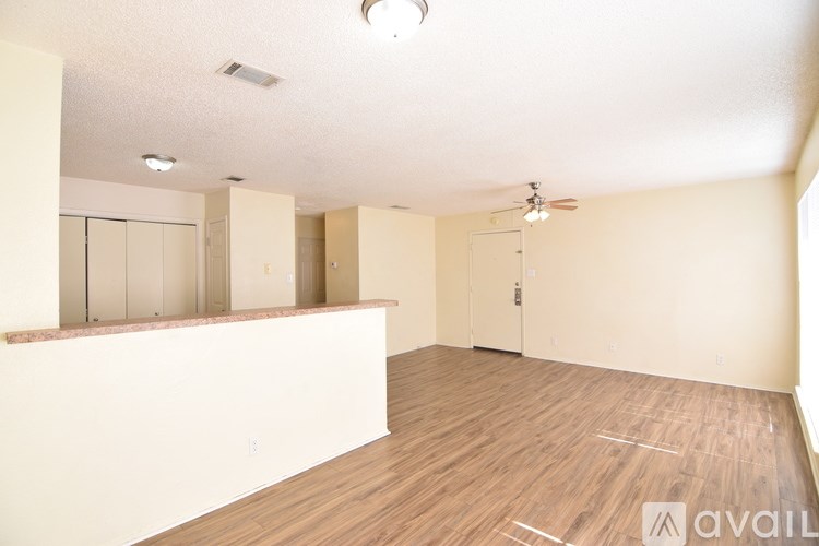 A room with wooden flooring and a ceiling fan.