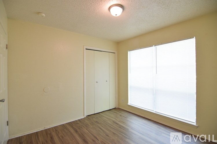 A room with a white door and a window with blinds.